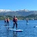 Guests on stand up paddleboards in the waters near Alesund, Norway